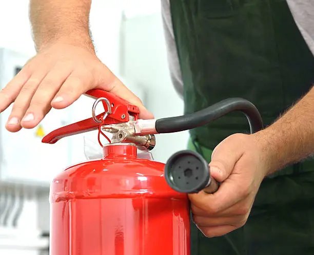 Agent SSIAP utilisant un extincteur — sécurité incendie en ERP et IGH